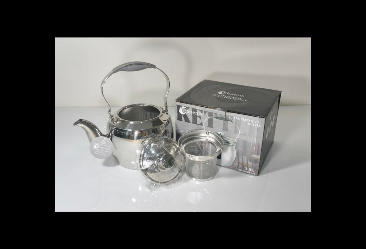 A stainless steel kettle with a gray handle and spout, shown with its lid, infuser basket, and retail box on a white surface against a white background.